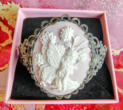 Cameo brooch with floral design in a decorative box on a patterned background